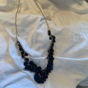 Black with gold colored chain. This necklace is long.